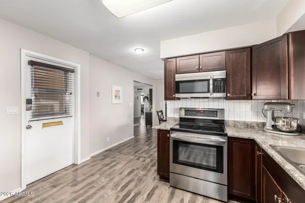 a kitchen with granite countertop a stove and a microwave