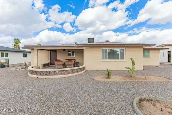 a view of a house with backyard and sitting area
