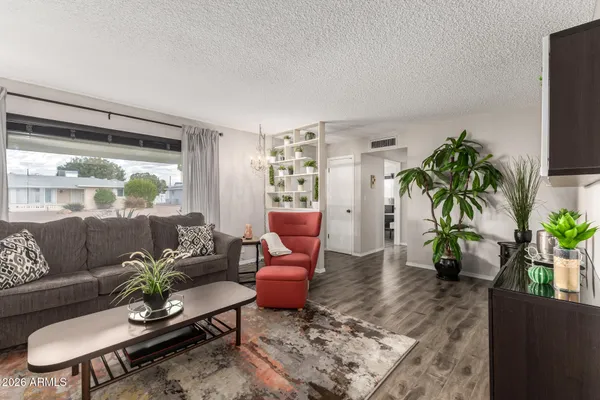 a living room with furniture potted plant and a large window