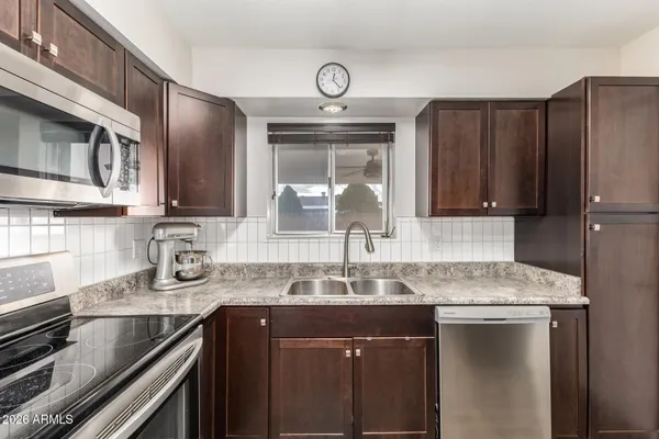 a kitchen with granite countertop a sink stove and refrigerator