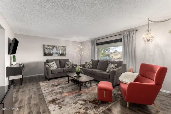 a living room with furniture wooden floor and a flat screen tv