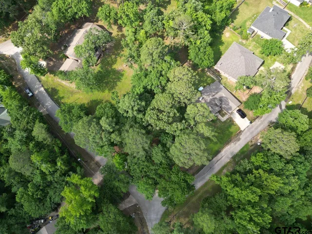 an aerial view of residential house with outdoor space and trees all around
