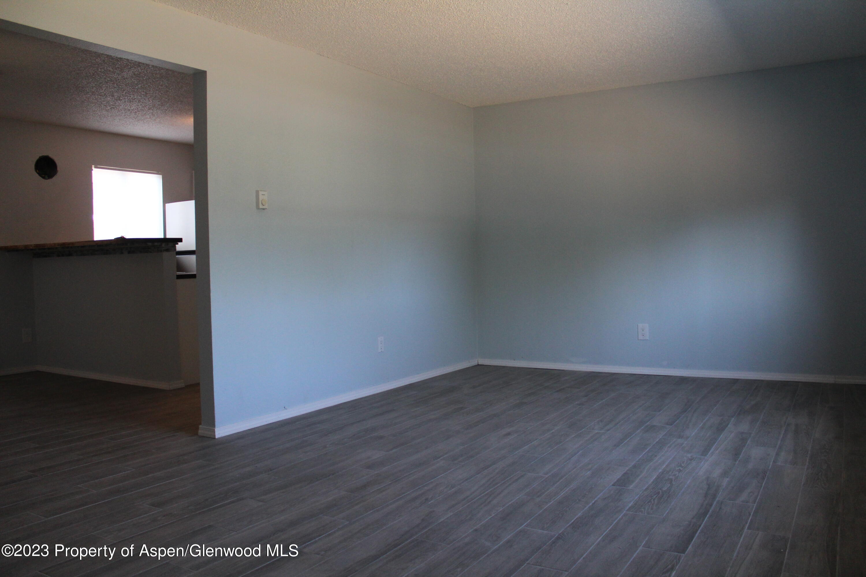1322 East 7th Street, Unit 3 Rifle, CO 81650 - Photo 6 of 8 a view of an empty room with wooden floor and a window