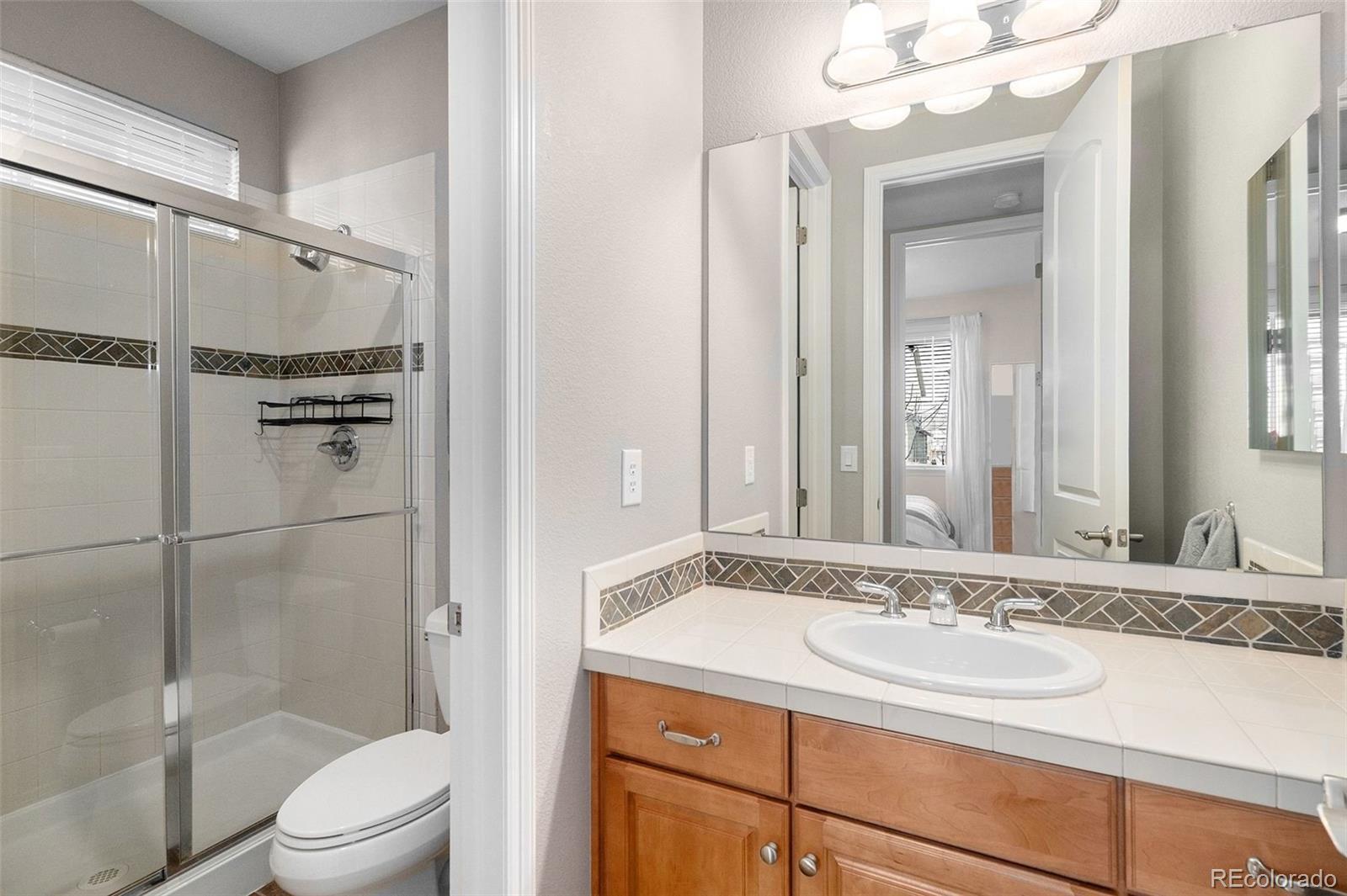 10869 Valleybrook Circle Highlands Ranch, CO 80130 - Photo 15 of 46 a bathroom with a granite countertop sink toilet and shower