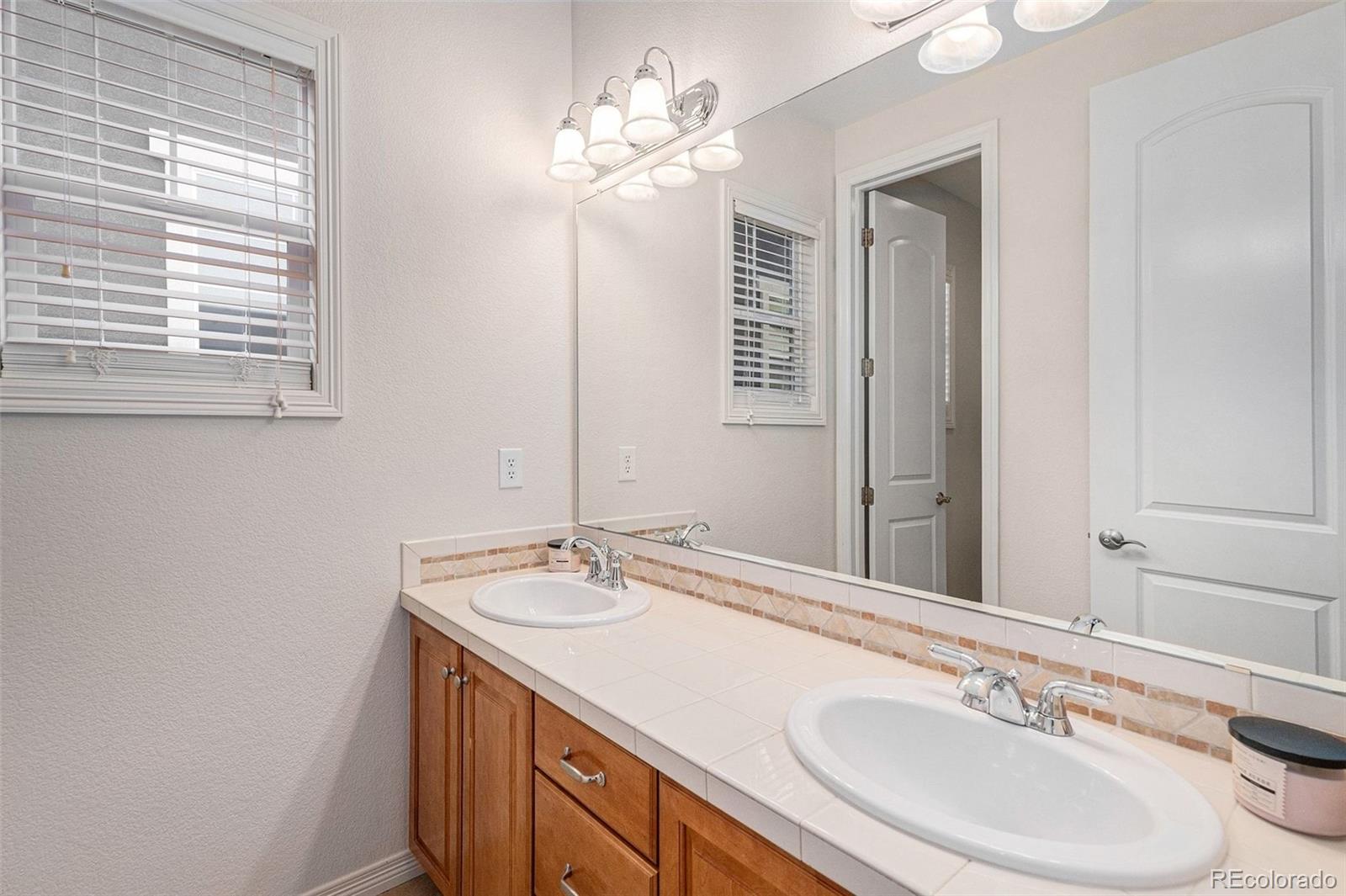 10869 Valleybrook Circle Highlands Ranch, CO 80130 - Photo 30 of 46 a bathroom with a sink vanity and a mirror