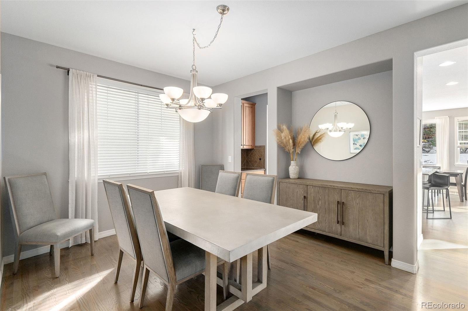 10869 Valleybrook Circle Highlands Ranch, CO 80130 - Photo 3 of 46 a view of a dining room with furniture a chandelier and wooden floor