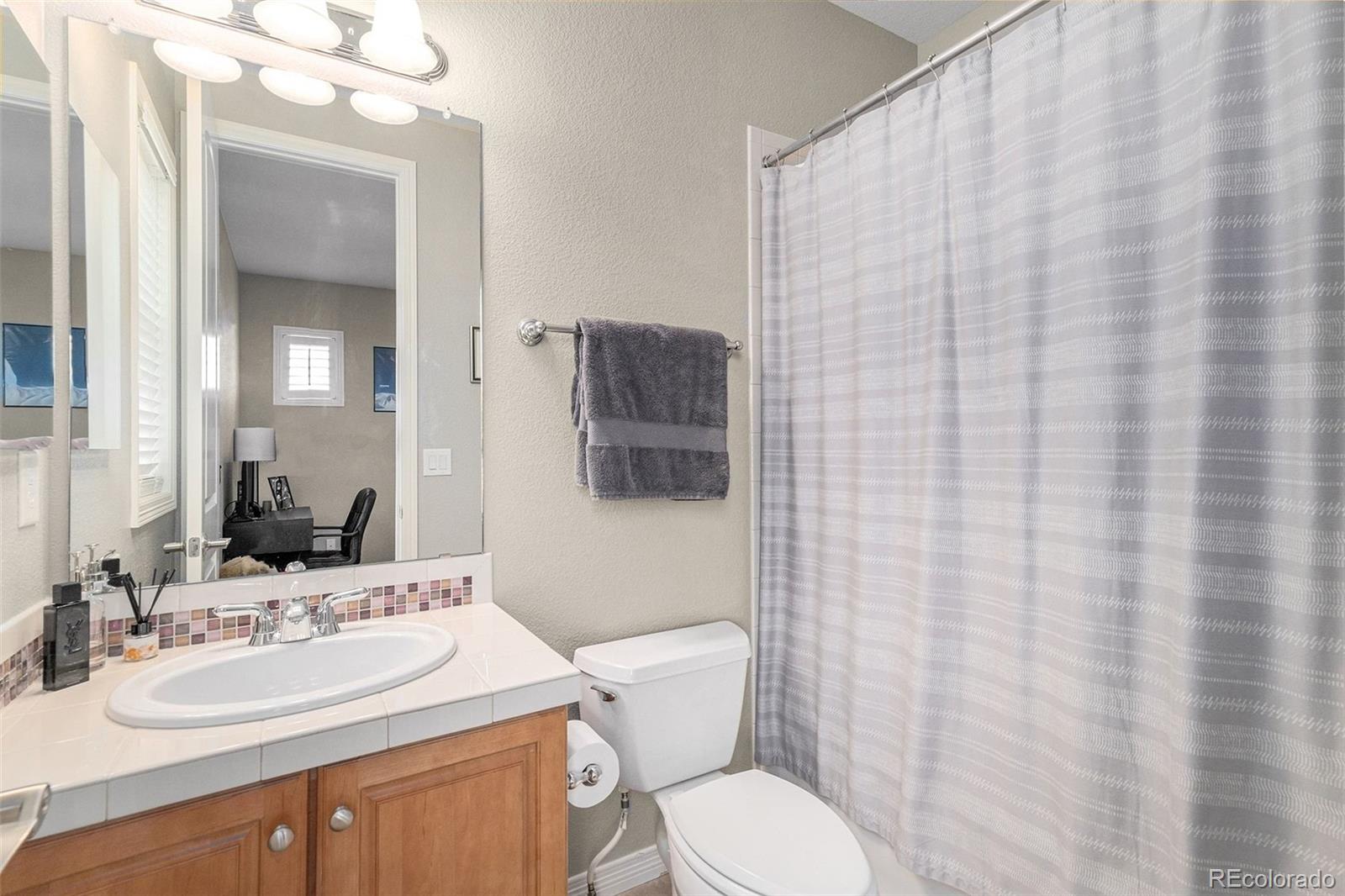 10869 Valleybrook Circle Highlands Ranch, CO 80130 - Photo 33 of 46 a bathroom with a sink vanity mirror and toilet