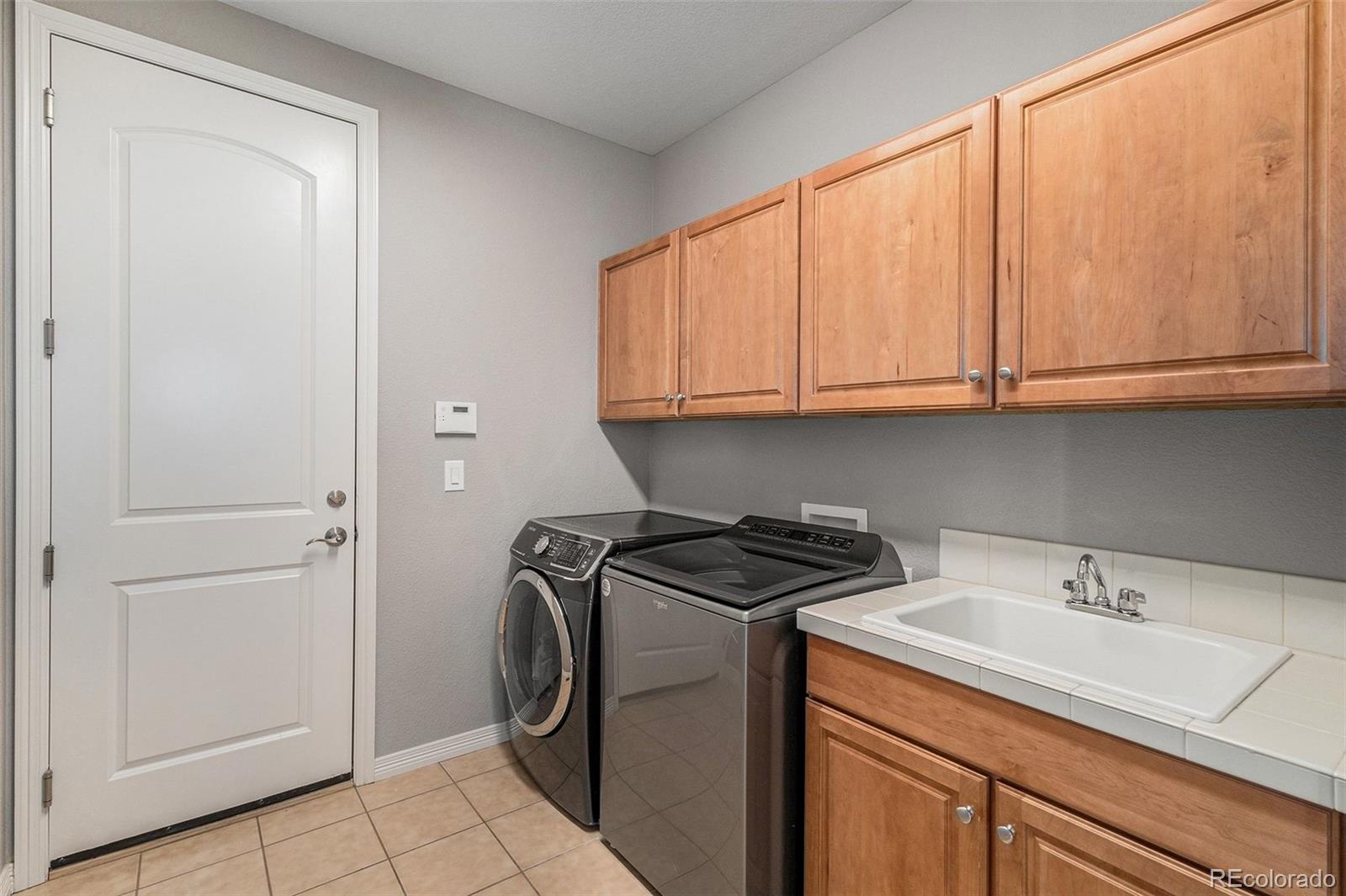10869 Valleybrook Circle Highlands Ranch, CO 80130 - Photo 37 of 46 a utility room with sink dryer and washer