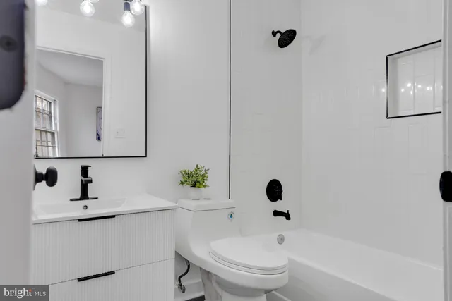 a bathroom with a toilet sink a mirror and shower