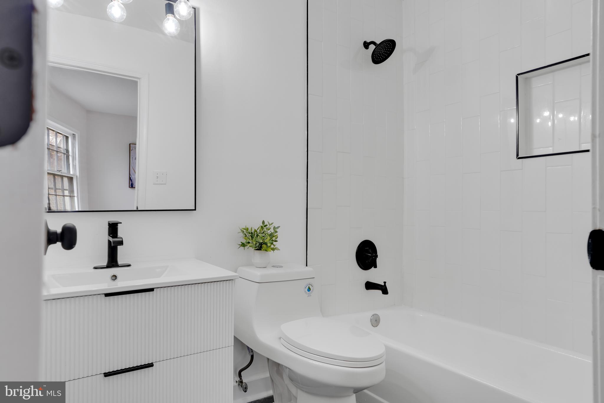 4339 Massachusetts Avenue Northwest, Unit 4339 Washington, DC 20016 - Photo 22 of 25 a bathroom with a toilet sink a mirror and shower