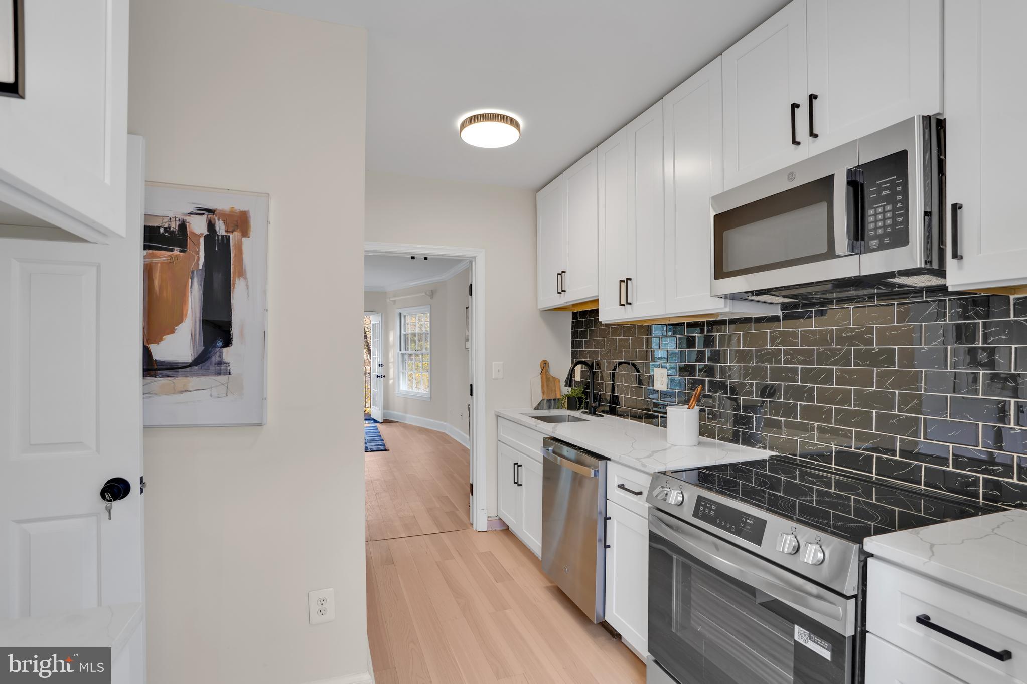 4339 Massachusetts Avenue Northwest, Unit 4339 Washington, DC 20016 - Photo 8 of 25 a kitchen with a stove and a microwave