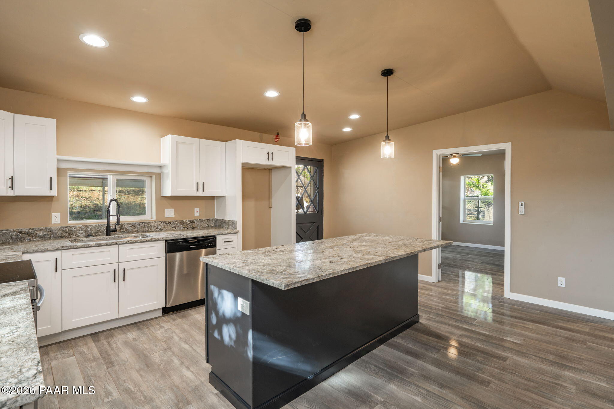 10101 Third Street Mayer, AZ 86333 - Photo 12 of 23 a large kitchen with granite countertop a large kitchen island white cabinets and stainless steel appliances