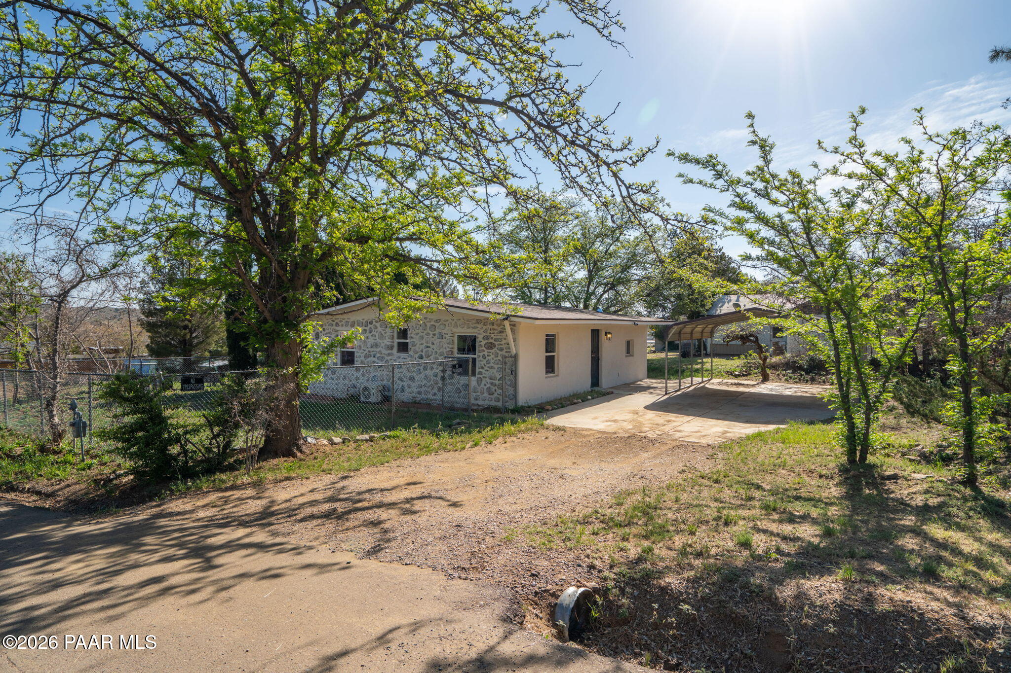 10101 Third Street Mayer, AZ 86333 - Photo 5 of 23 a backyard of a house with a large tree and wooden fence