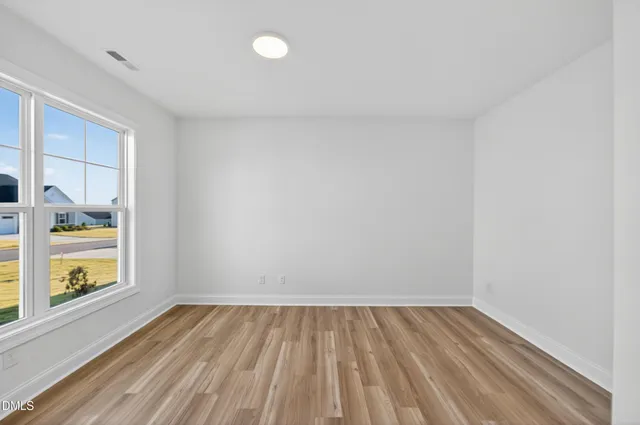 a view of a hallway with wooden floor and closet