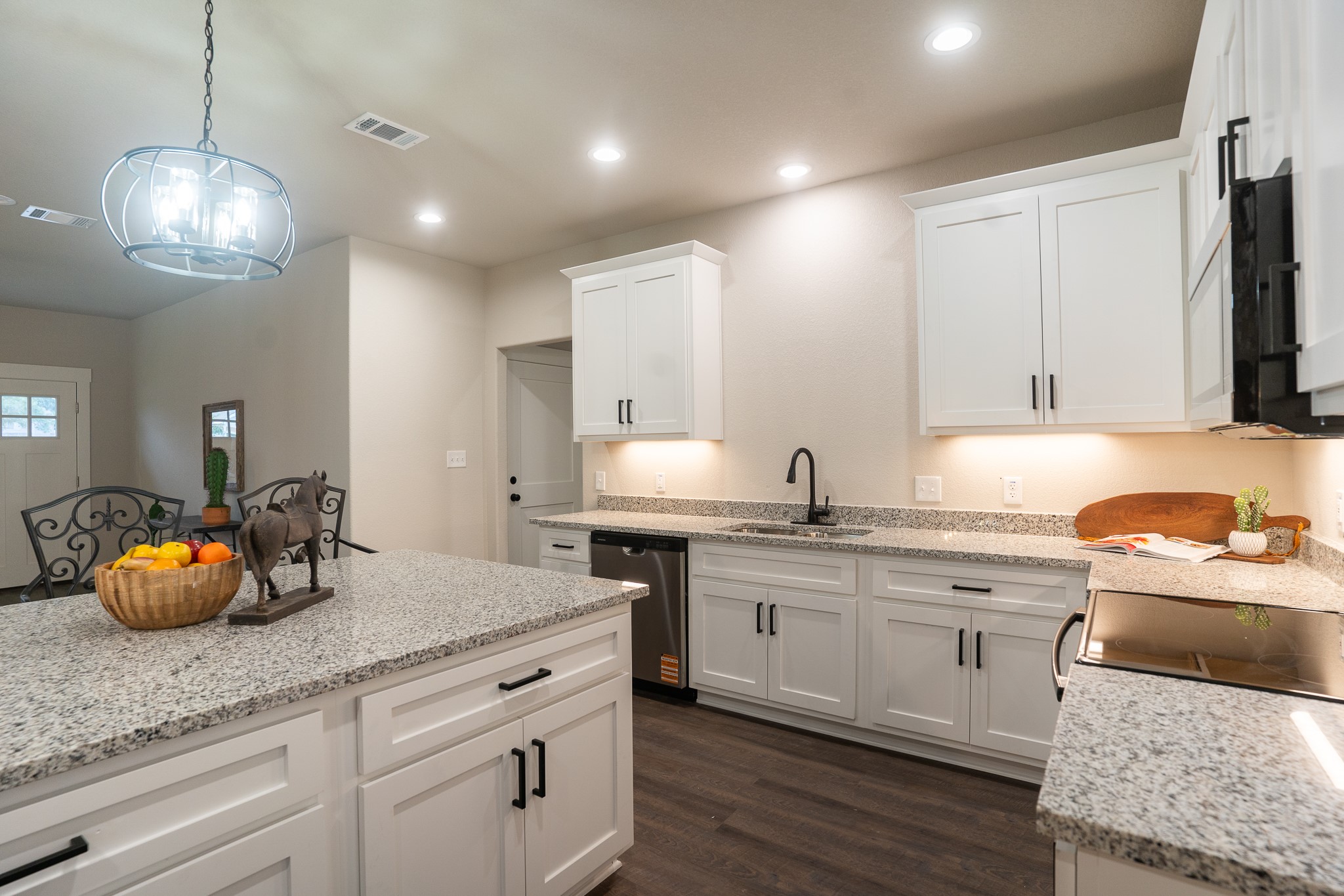 306 String Prairie Way Smithville, TX 78957 - Photo 11 of 25 Kitchen featuring a sink, dishwasher, dark wood-type flooring, white cabinets, and pendant lighting