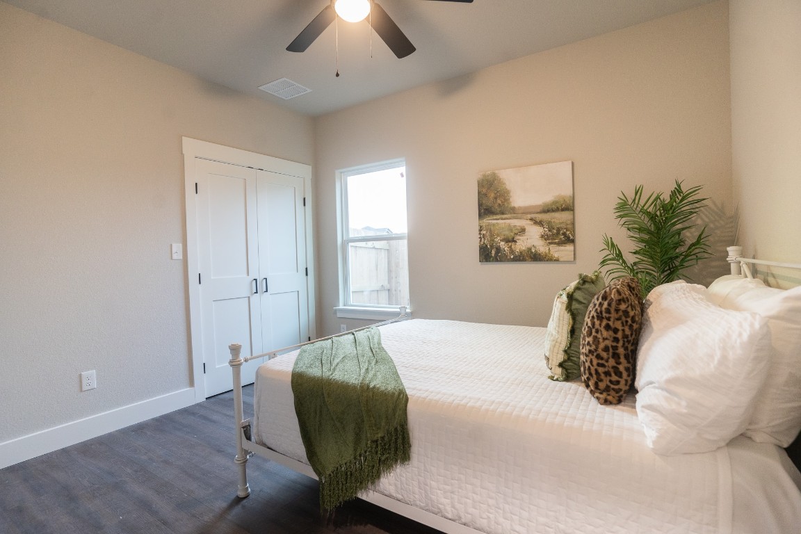 306 String Prairie Way Smithville, TX 78957 - Photo 18 of 25 Bedroom featuring dark wood-style flooring, baseboards, ceiling fan, and a closet
