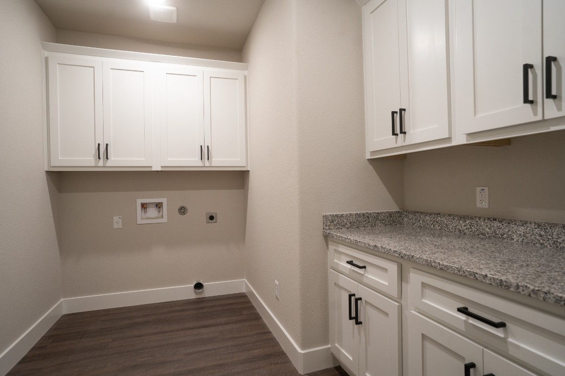 306 String Prairie Way Smithville, TX 78957 - Photo 20 of 25 Laundry area with cabinet space, hookup for an electric dryer, washer hookup, dark wood-type flooring, and baseboards