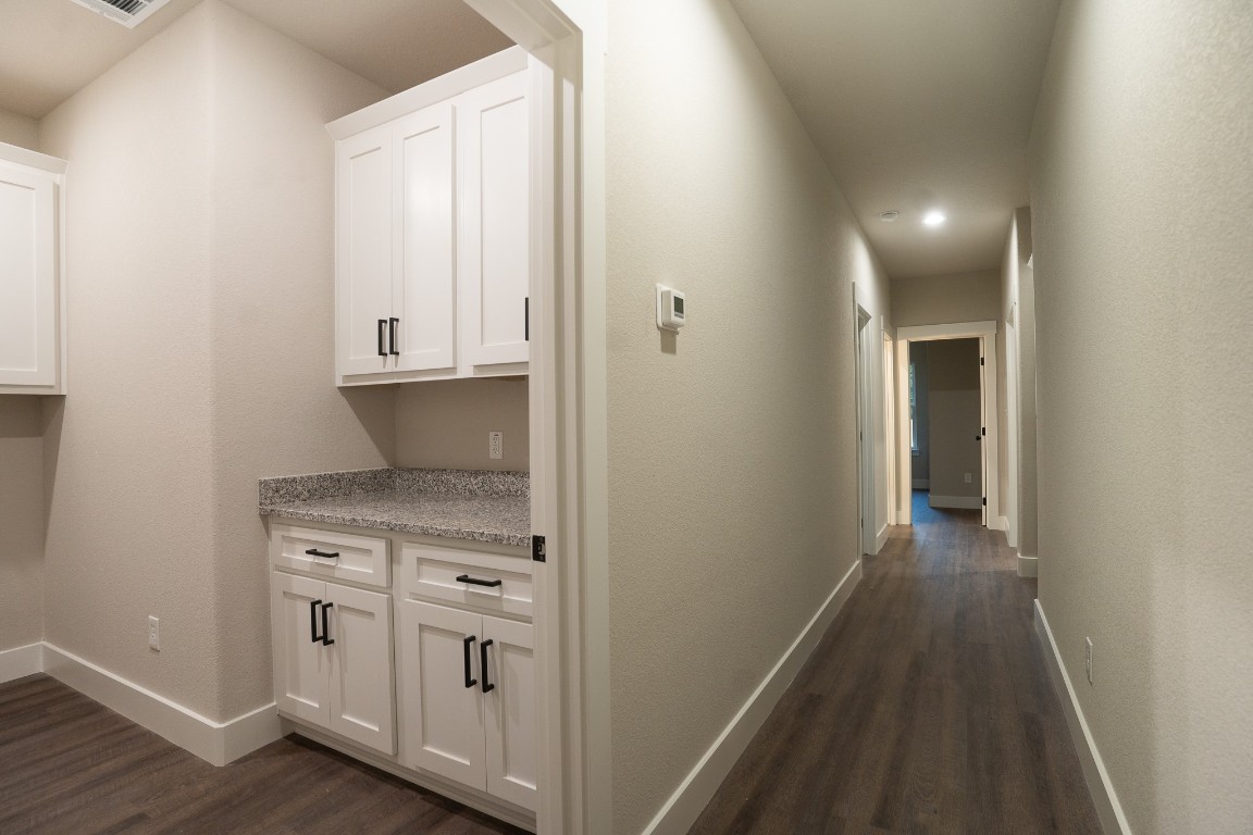 306 String Prairie Way Smithville, TX 78957 - Photo 21 of 25 Hall with dark wood-style floors, baseboards, and recessed lighting