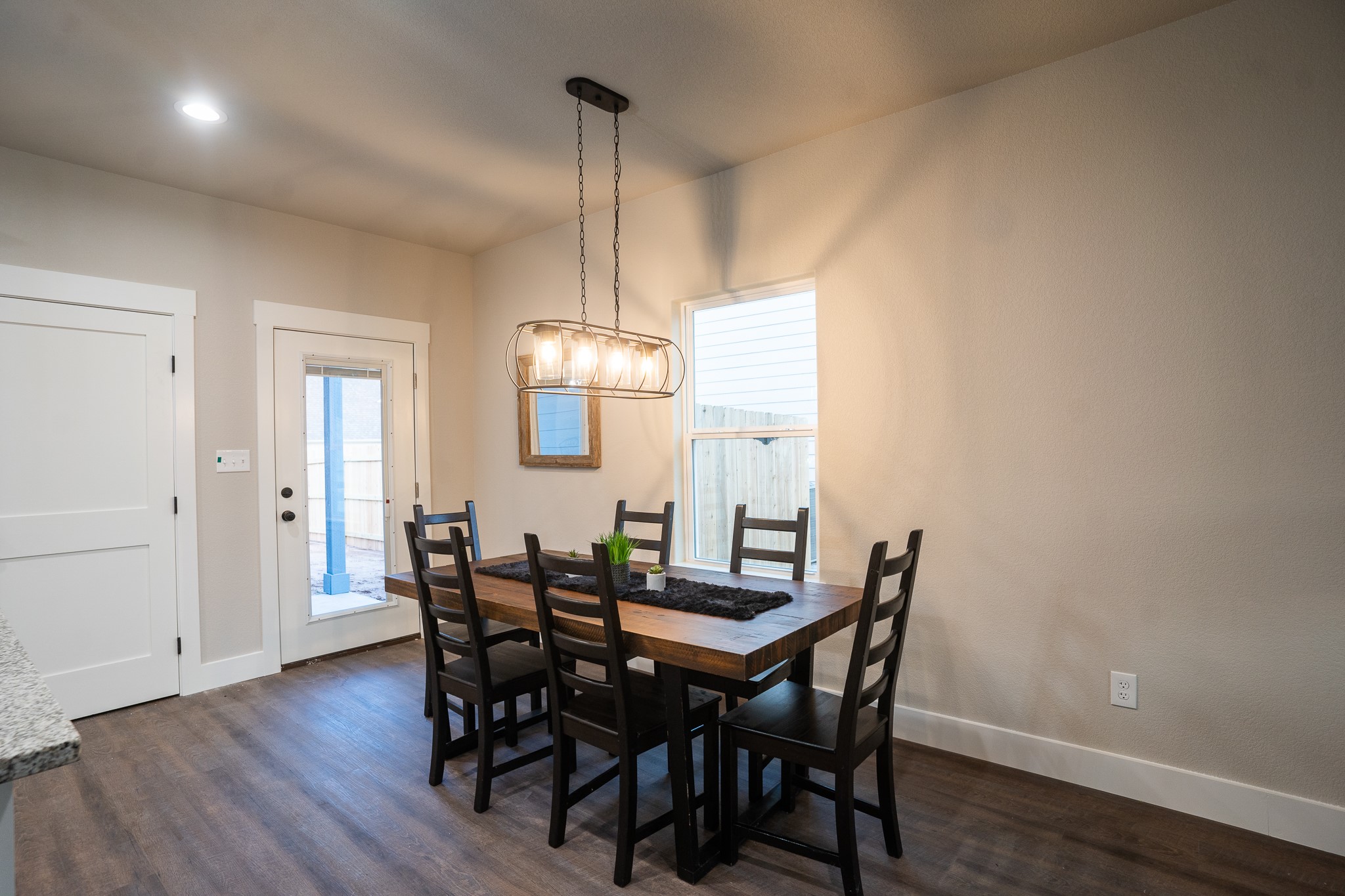 306 String Prairie Way Smithville, TX 78957 - Photo 6 of 25 Dining space featuring dark wood-style floors, baseboards, and a chandelier