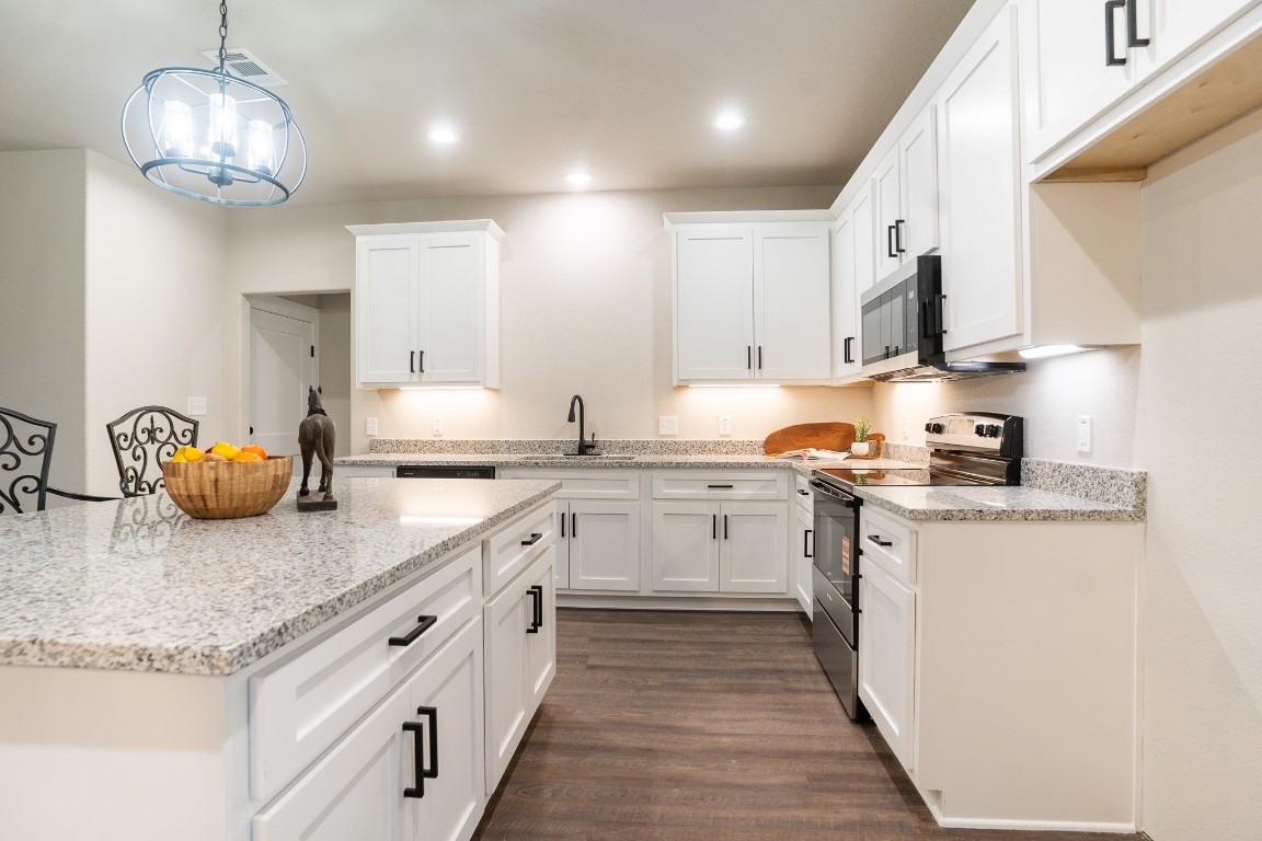 306 String Prairie Way Smithville, TX 78957 - Photo 8 of 25 Kitchen featuring stainless steel appliances, a sink, white cabinets, dark wood-style flooring, and recessed lighting