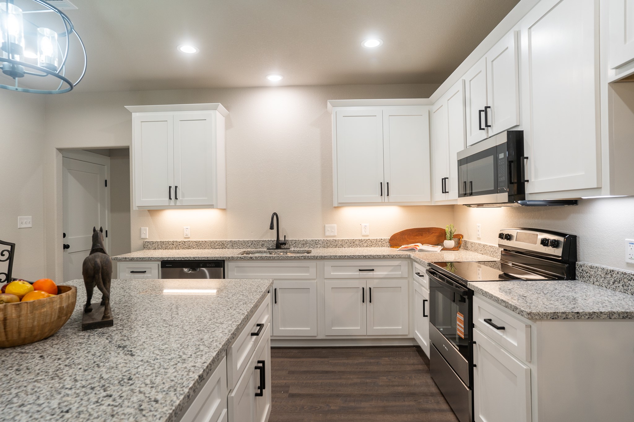 306 String Prairie Way Smithville, TX 78957 - Photo 10 of 25 Kitchen featuring stainless steel appliances, a sink, white cabinets, dark wood-style floors, and recessed lighting