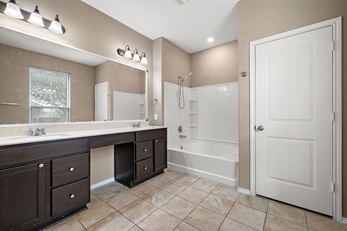 1012 Plano Lane Leander, TX 78641 - Photo 13 of 21 a spacious bathroom with a shower a sink and a large mirror