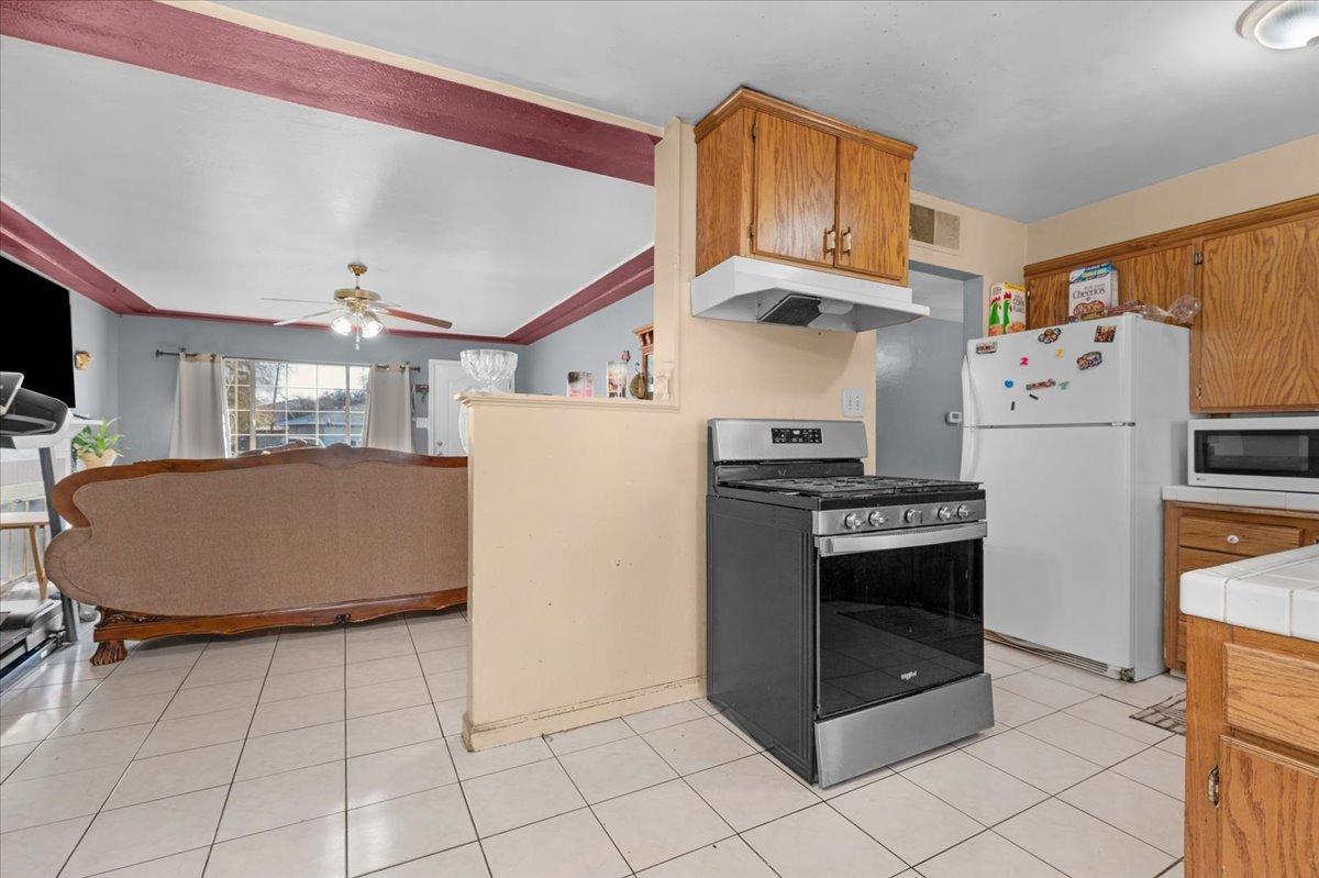 4185 East Turner Avenue Fresno, CA 93702 - Photo 13 of 39 a kitchen with stainless steel appliances granite countertop a refrigerator sink and stove