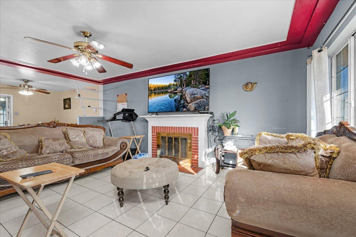 4185 East Turner Avenue Fresno, CA 93702 - Photo 6 of 39 a living room with furniture a fireplace and a flat screen tv