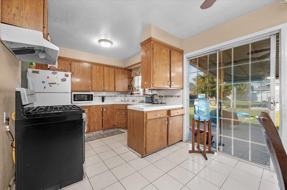4185 East Turner Avenue Fresno, CA 93702 - Photo 9 of 39 a kitchen with granite countertop a sink a counter top space appliances and cabinets