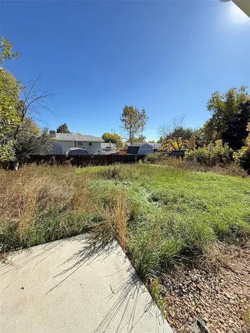 a view of a house with a yard and large trees