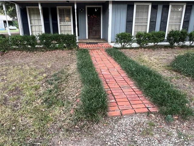 front view of a brick house with a yard