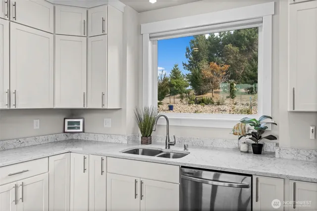 a kitchen with stainless steel appliances white cabinets and a window