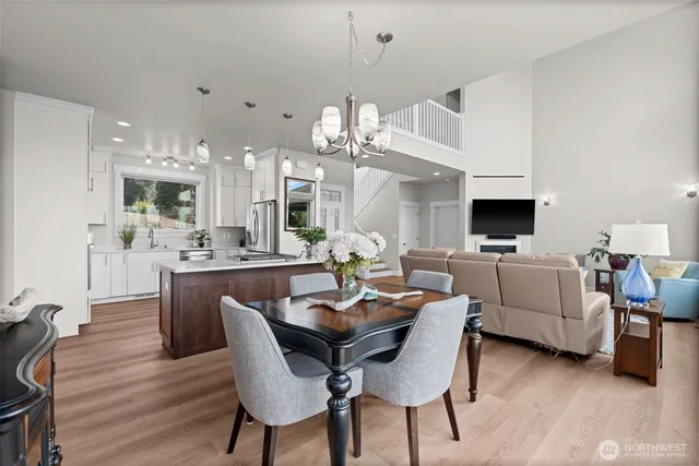 a dining room with wooden floor a chandelier a wooden table and chairs