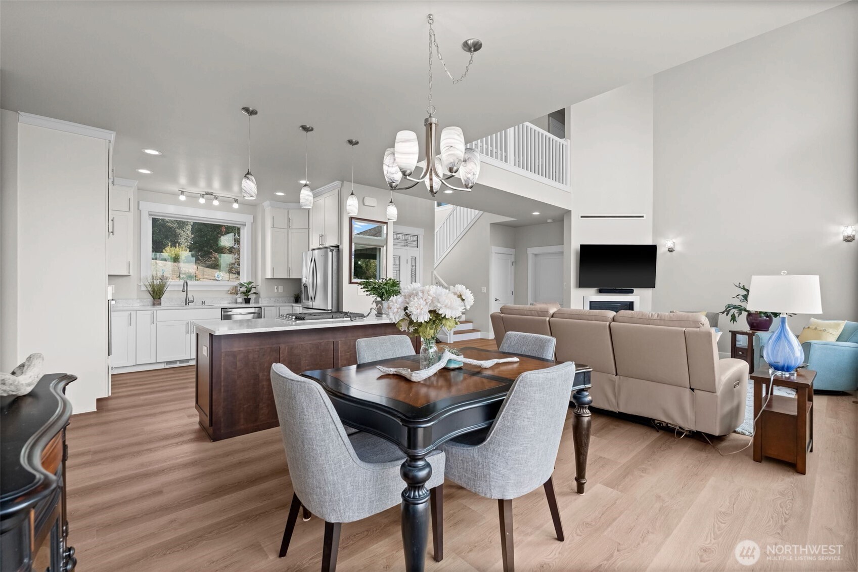 460 East Stretch Island Road South Grapeview, WA 98546 - Photo 13 of 39 a dining room with wooden floor a chandelier a wooden table and chairs