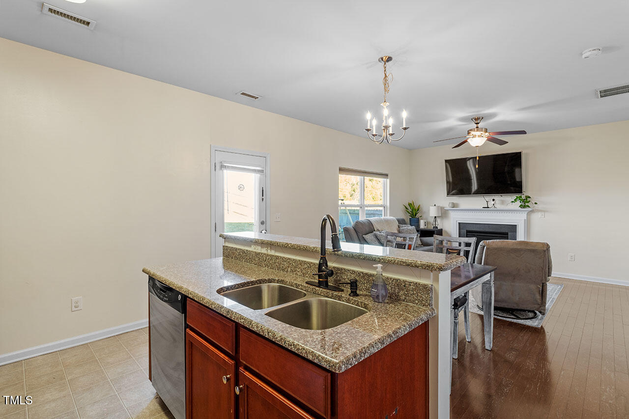 4817 Kitledge Drive Raleigh, NC 27610 - Photo 13 of 28 a kitchen with granite countertop a sink a counter top space and living room area