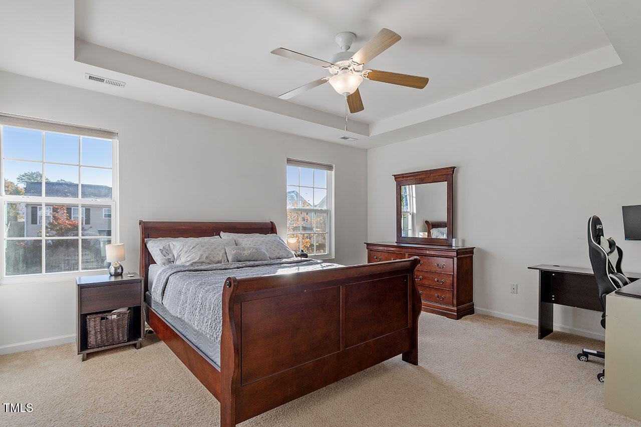 4817 Kitledge Drive Raleigh, NC 27610 - Photo 16 of 28 a bedroom with a large bed and a chandelier fan