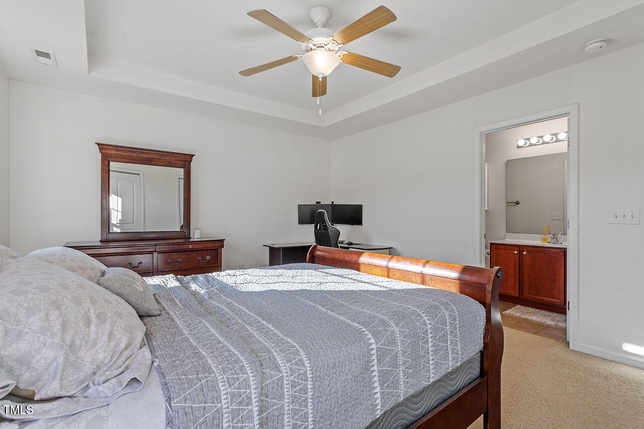 4817 Kitledge Drive Raleigh, NC 27610 - Photo 17 of 28 a bedroom with a bed and a chandelier