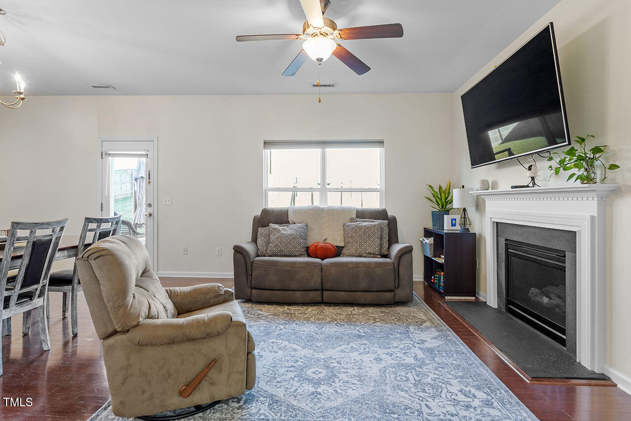 4817 Kitledge Drive Raleigh, NC 27610 - Photo 4 of 28 a living room with furniture a flat screen tv and a fireplace