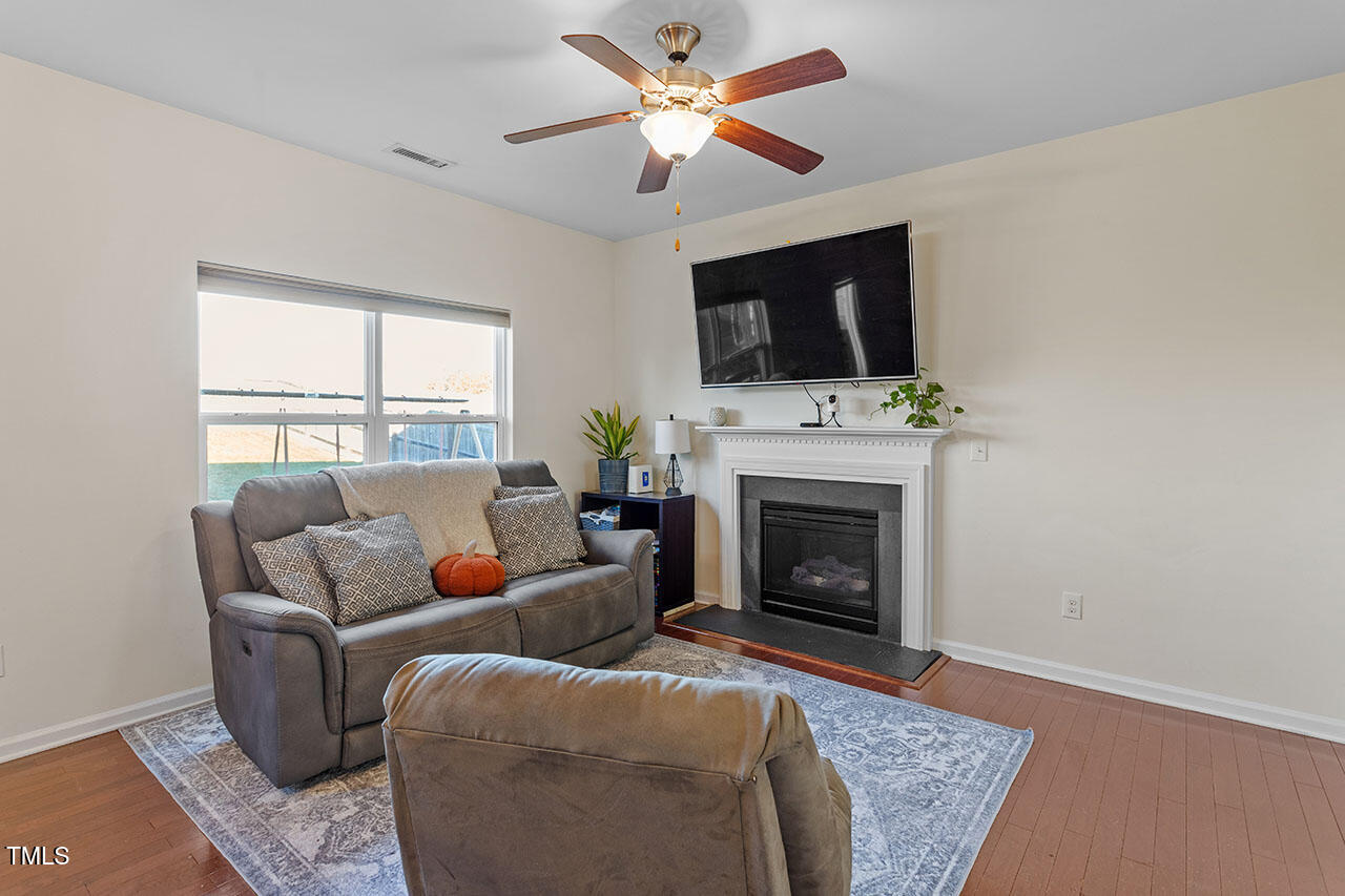 4817 Kitledge Drive Raleigh, NC 27610 - Photo 5 of 28 a living room with furniture a fireplace and a flat screen tv