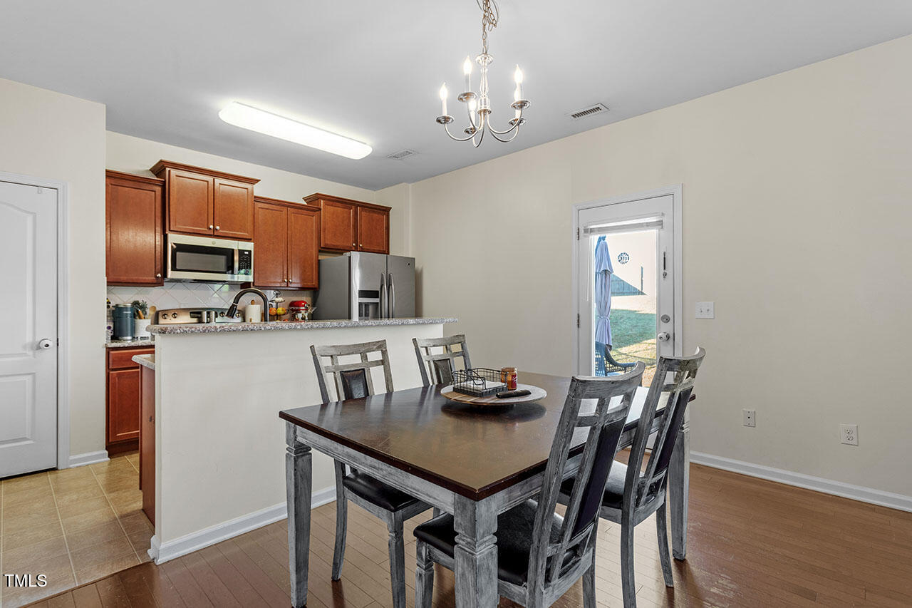 4817 Kitledge Drive Raleigh, NC 27610 - Photo 8 of 28 a kitchen with kitchen island a dining table and chairs
