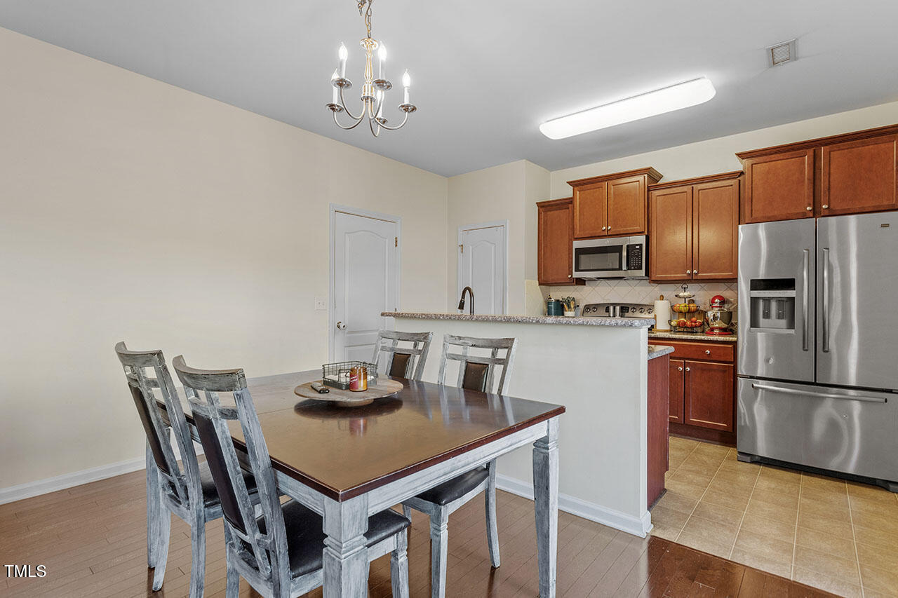 4817 Kitledge Drive Raleigh, NC 27610 - Photo 9 of 28 a kitchen with stainless steel appliances granite countertop a dining table and chairs
