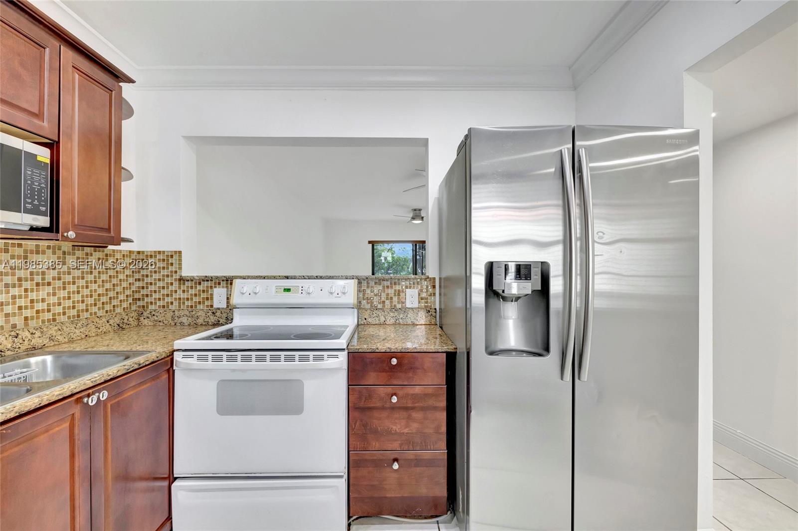 126 South Cypress Road, Unit 729 Pompano Beach, FL 33060 - Photo 12 of 26 a kitchen with a refrigerator and a stove