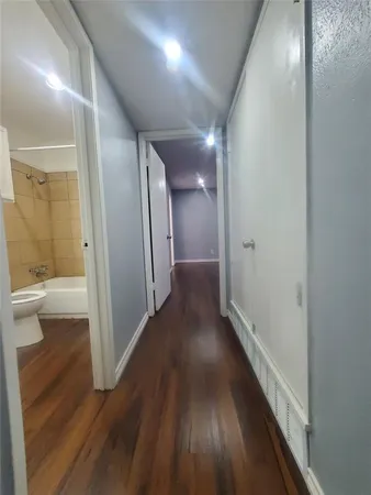 a view of a hallway with wooden floor
