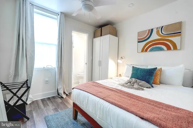 a bedroom with a bed and painting on the wall