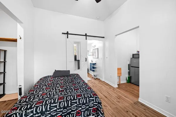 a bedroom with a bed and wooden floor