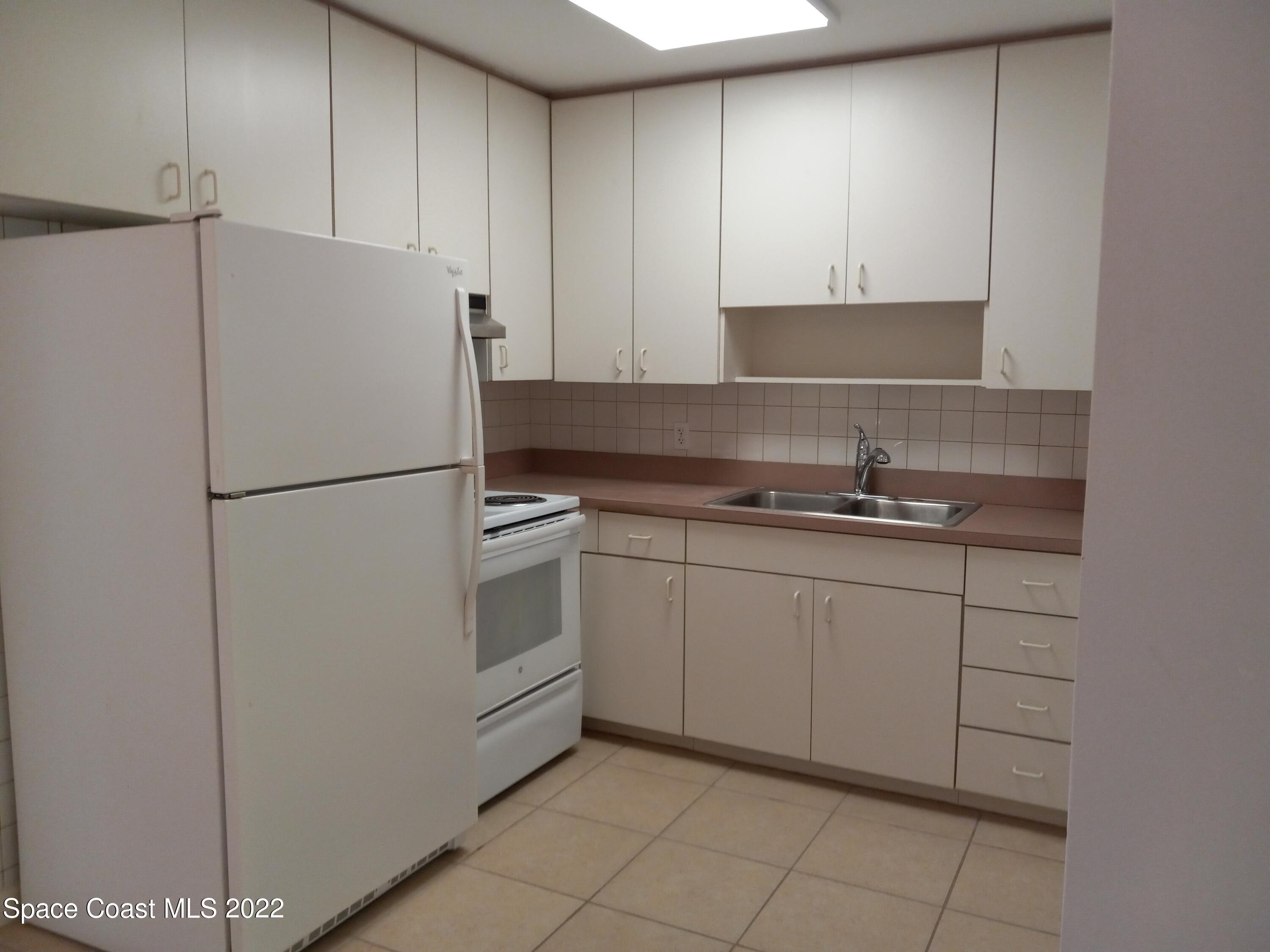 2567 Coventry Road Melbourne, FL 32935 - Photo 2 of 9 a kitchen with cabinets and a refrigerator