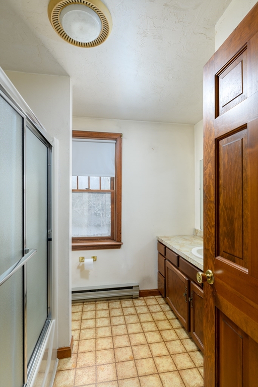 224 Podunk Road Sturbridge, MA 01566 - Photo 18 of 26 a bathroom with a granite countertop sink a mirror and a shower