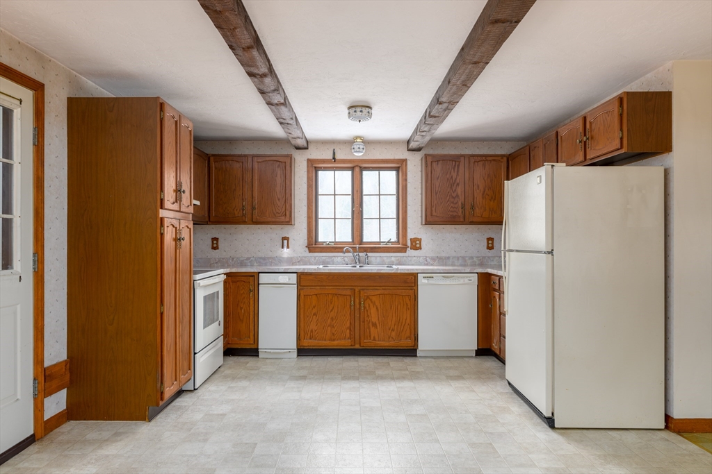 224 Podunk Road Sturbridge, MA 01566 - Photo 6 of 26 a kitchen with white cabinets and refrigerator