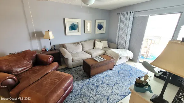a living room with furniture a ceiling fan and a window