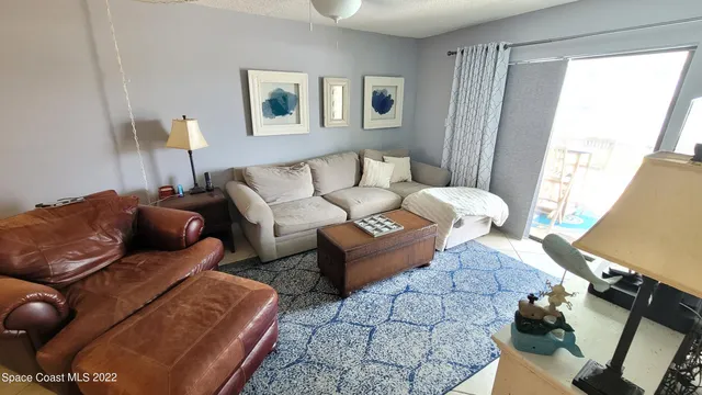 a living room with furniture a ceiling fan and a window